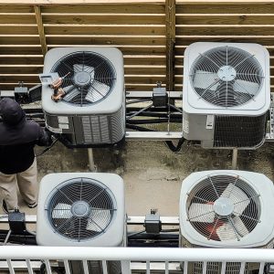 HVAC technician using modern technology instruments to analyze HVAC units in beach condo.